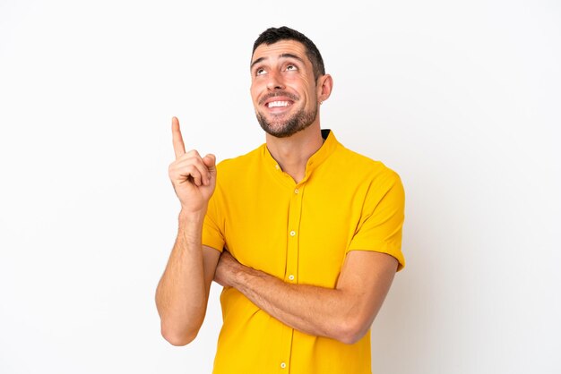 Young woman over yellow wall surprised and shocked while looking right