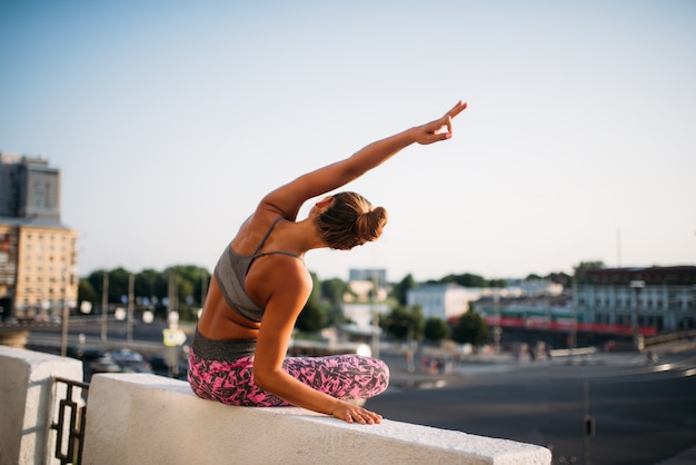 Young woman in yoga pose, city