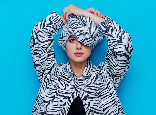 Young woman in zebra clothes on blue background