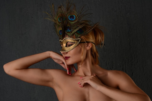 若い女性のベネチアンカーニバルマスククローズアップ女性の肖像画。暗い背景