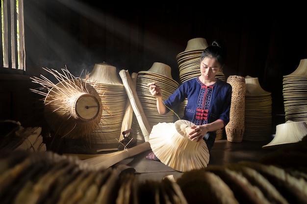 Young women are weaving in field handmade basket of Thailand.