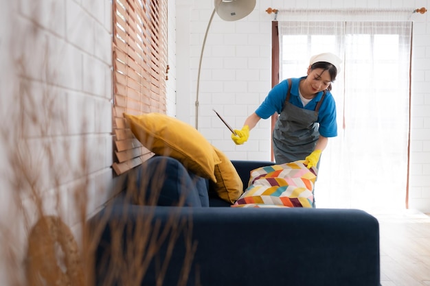 Young women cleaning maid in uniform are cleaning the living room at home