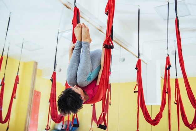 Young women doing yoga exercise or aerial yoga antigravity in the studio.