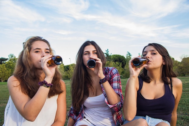 Young women drinking beer in the park