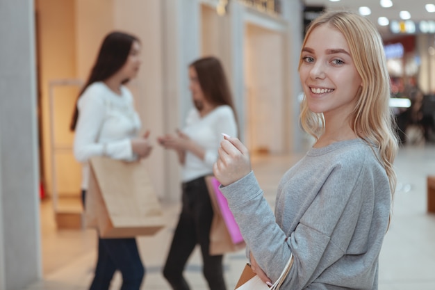 Giovani donne che godono della compera insieme al centro commerciale