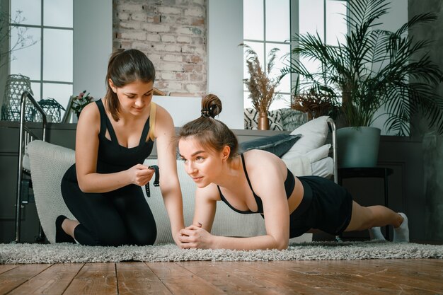 Le giovani donne praticano sport a casa, si allenano online