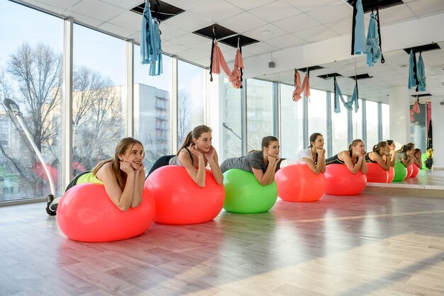 Young women in gym training on gymnastic ball