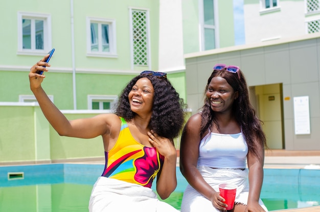 Young women having fun by the pool at summer day