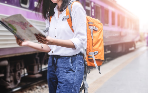 若い女性が駅に手をつないで地図を保持