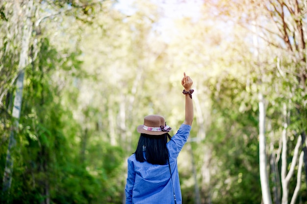 Young women love and fall in love with beautiful nature. And look forward happily, with a gesture of the forest love concept