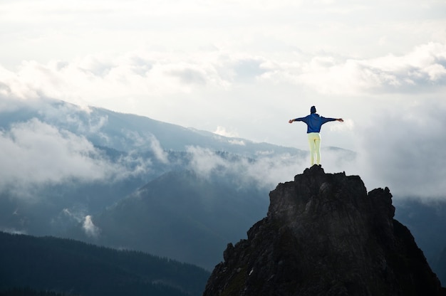 写真 山の頂上にいる若い女性。