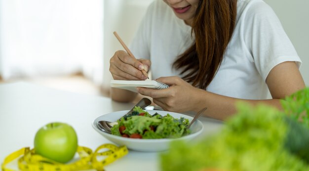 Young women plan meals during weight loss. Health care women choose keto.