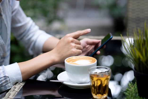 Photo young women play smartphones.