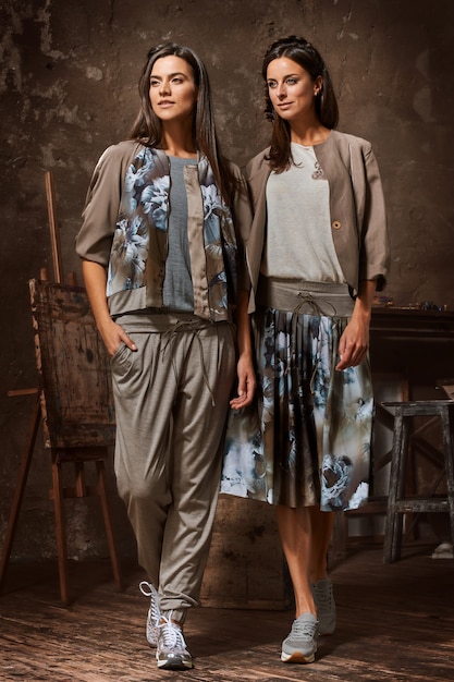 Young women poses in studio of the artist on dark background