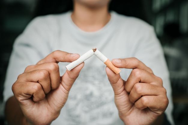 Giovani donne che rifiutano il concetto di sigarette per smettere di fumare e uno stile di vita sano sfondo scuro. o no smoking concetto di campagna.