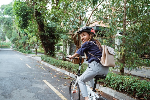 道路で折りたたみ自転車に乗る若い女性