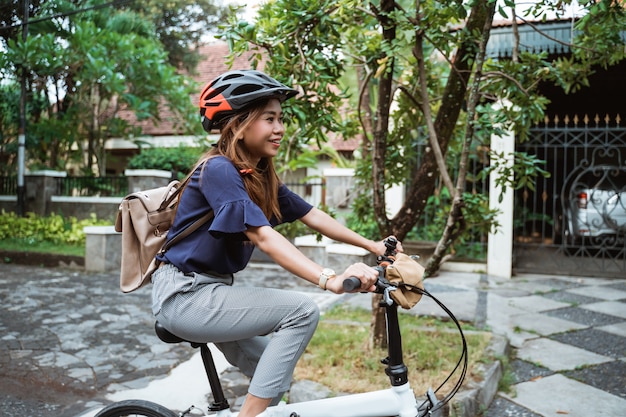 道路で折りたたみ自転車に乗る若い女性