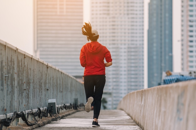 写真 路上で若い女性ランナーが市の道路で運動をしている。スポーツ、人々、運動、ライフスタイルコンセプト