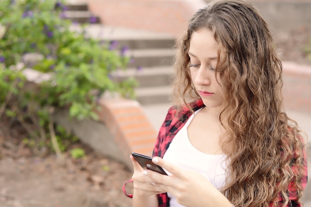 スマートフォンでメッセージを送る若い女性。