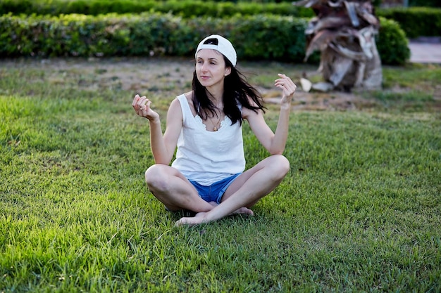 Photo young women sits on the lawn and practices breathing exercises meditation breathwork concept oxygen training high quality photo