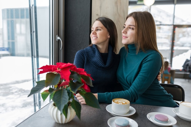 コーヒーショップのテーブルに座っている若い女性