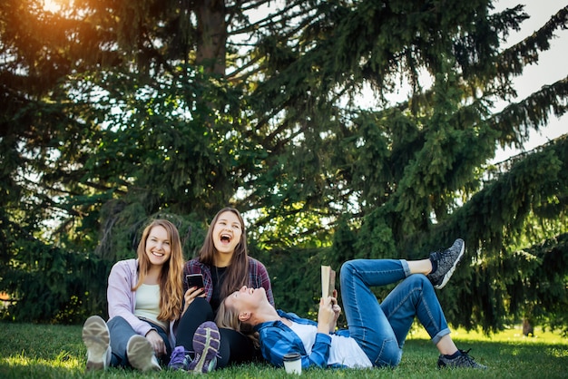 Young women sitting together on a meadow