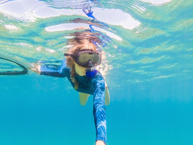 Молодые женщины на подводном плавании в тропической воде