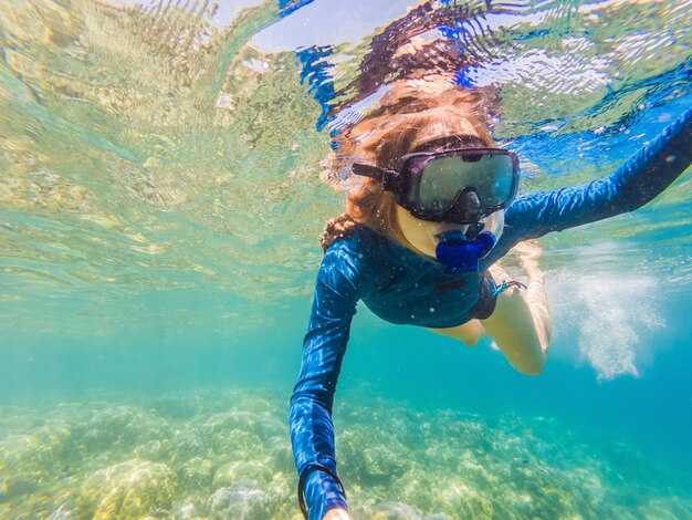 熱帯の水でシュノーケリングをする若い女性