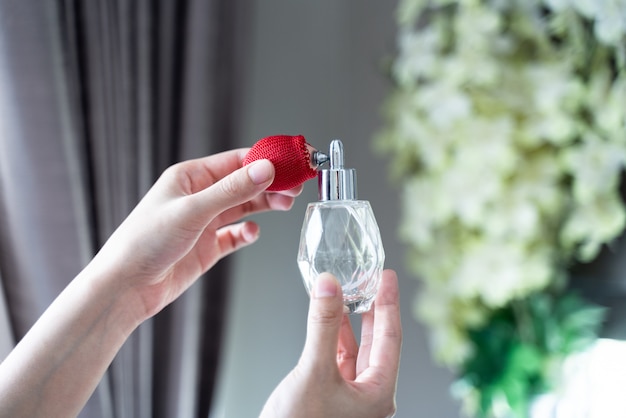 Young women spraying perfume 