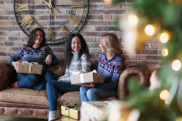 若い女性はクリスマスプレゼントでお互いを驚かせます