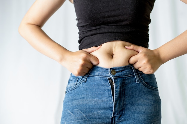 Young women touching his fat belly. Fat and Health concept