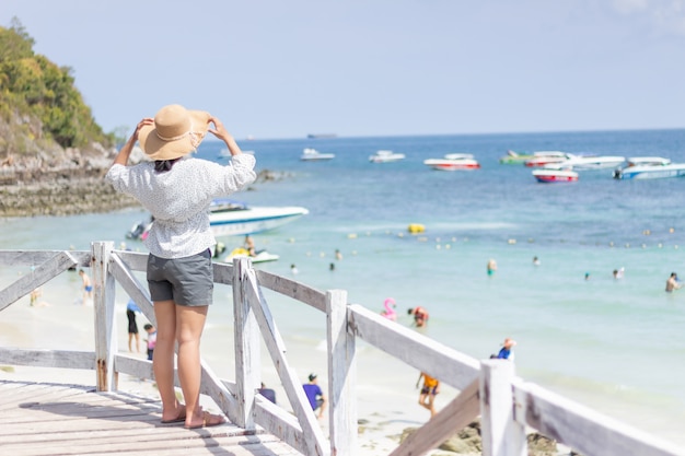 Le giovani donne che viaggiano si rilassano sulla spiaggia di estate