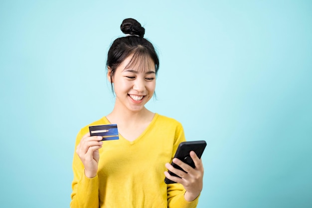 Young women use smartphones and credit cards