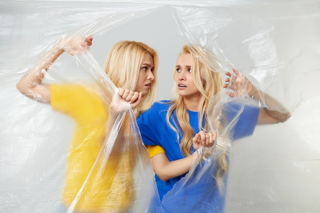 Молодые женщины-добровольцы в желтых и синих футболках проводят кампанию против использования полиэтилена и пластика. концепция утилизации отходов