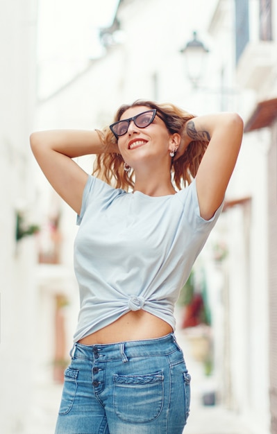 路上でTシャツとジーンズを着ている若い女性