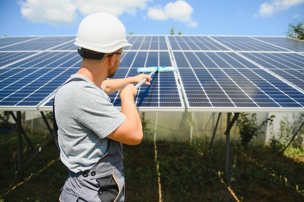 Young worker cleaning solar panels.