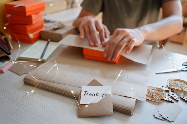 Young worker packing christmas gift boxes for clients family small business distant work from home