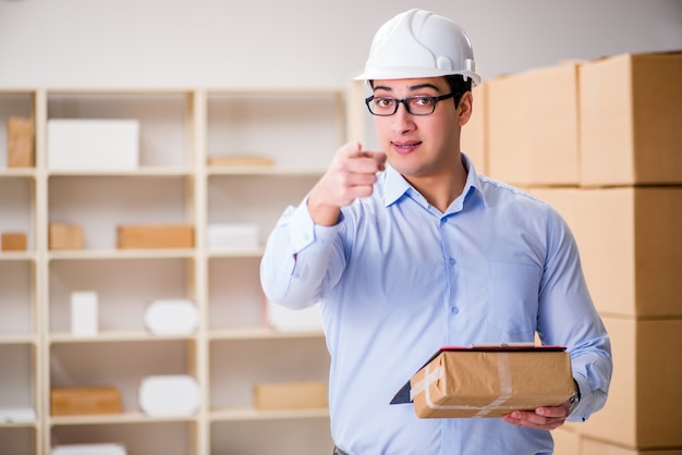 Young worker in the postal office dealing with parcels