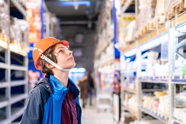 young worker in protective helmet sort products at the market b