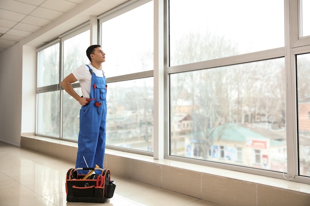 Young worker in room with big windows