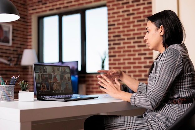 Young worker using remote videocall meeting to talk to\
colleagues on virtual conference with webcam. chatting on online\
videoconference call, having internet conversation on\
teleconference.