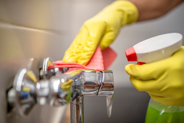 Young Worker Wearing Glove Cleaning Steel Sink In Kitchen Room