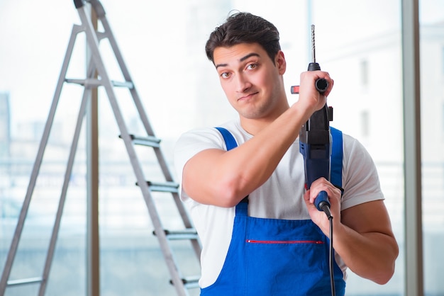 Young worker with hand drill