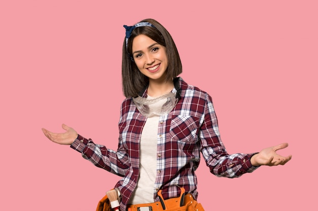 Young worker woman proud and self-satisfied on isolated pink wall