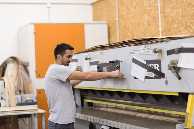 Foto giovane operaio lavora in una fabbrica per la produzione di mobili in legno