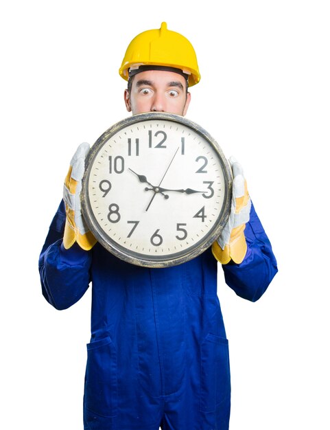 Young workman worried about the time on white background