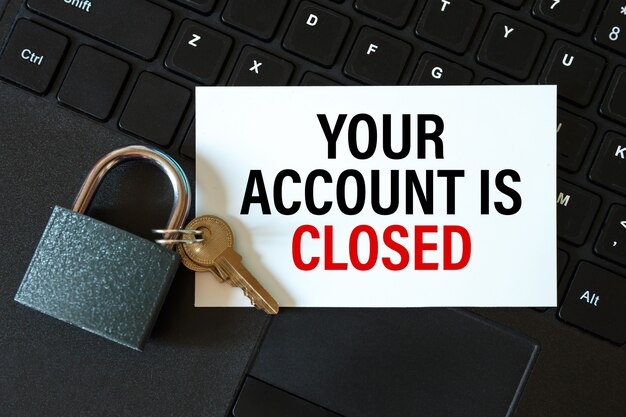 Your account is closed - an inscription on a card and a lock on the table by a computer