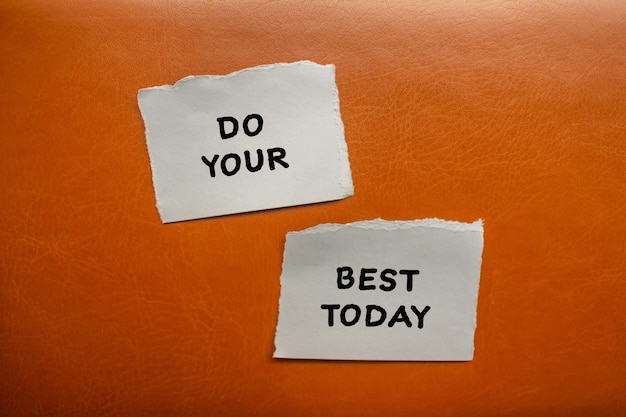 Do your best today words written on torn paper pieces with brown background