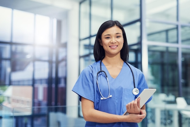 Your health is my priority Portrait of a young female doctor holding a digital tablet while standing in a hospital