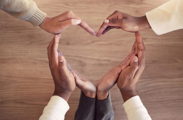 사진 심장 건강이 중요합니다. 그들의 손으로 심장 모양을 형성 하는 인식할 수 없는 기업인의 그룹의 높은 각도 샷.